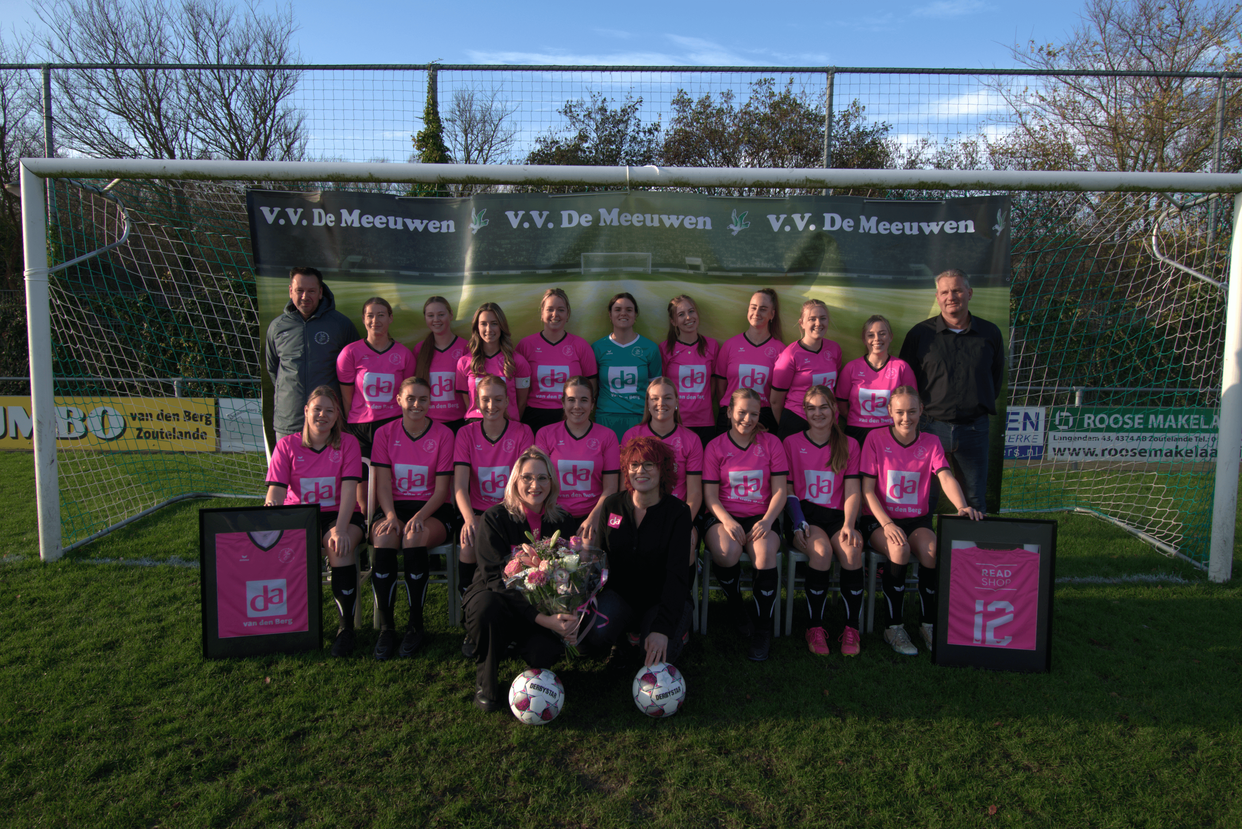 Alle leden van De Meeuwen VR1 poseren in de goal samen met de staf in het thuistenue.